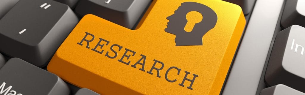 リサーチと書かれたオレンジ色のキーボードキーと頭脳アイコン